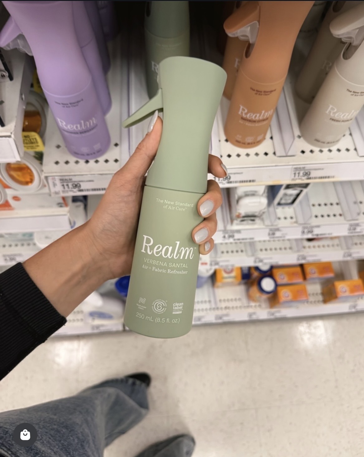 A shopper discovering Realm’s Verbena Santal air and fabric freshener on a retail shelf